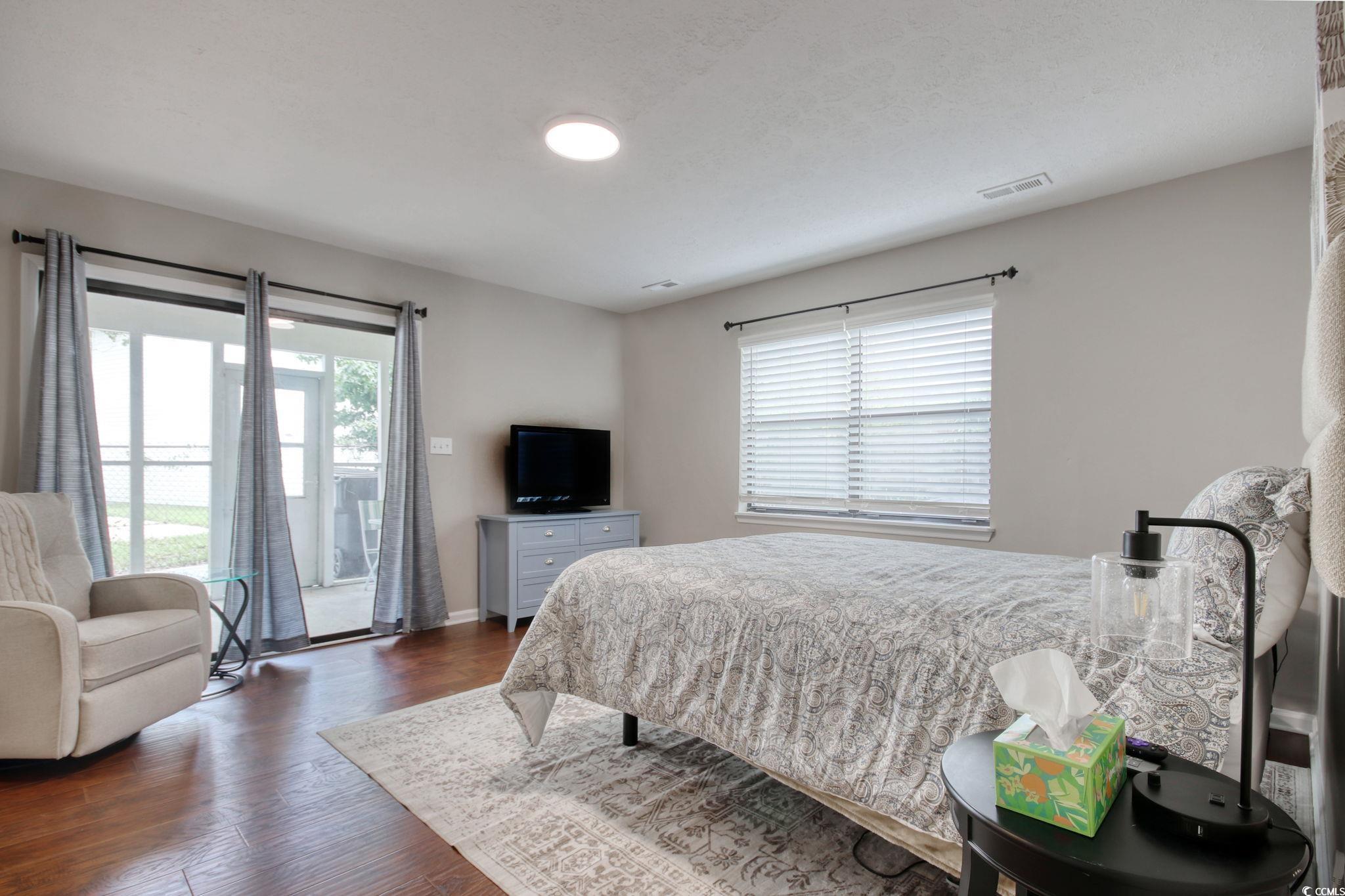 3931 Pinebrook Circle Little River, SC 29566 - Photo 22 of 32 Primary bedroom featuring wood flooring, walk-in closet and access to your outside screen porch.
