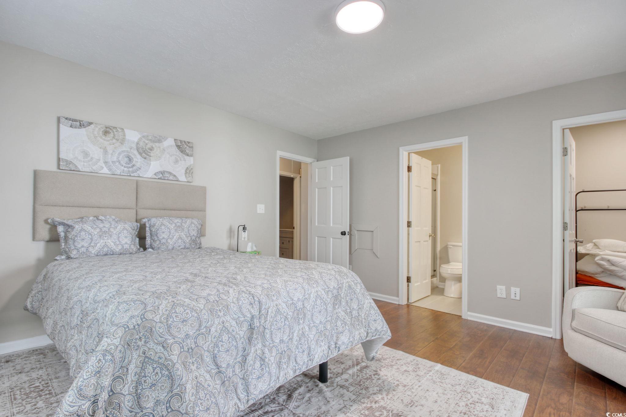 3931 Pinebrook Circle Little River, SC 29566 - Photo 23 of 32 Primary bedroom featuring wood flooring, walk-in closet and access to your outside screen porch.
