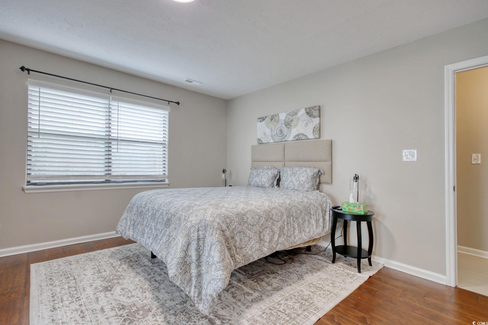 3931 Pinebrook Circle Little River, SC 29566 - Photo 24 of 32 Primary bedroom featuring wood flooring, walk-in closet and access to your outside screen porch.