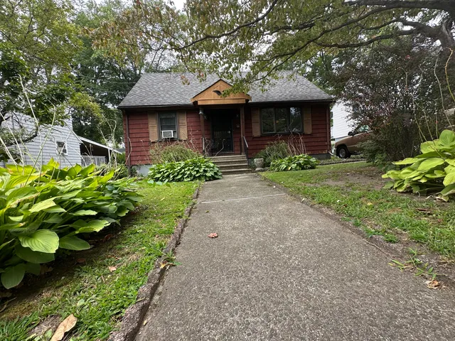 a front view of a house with a garden