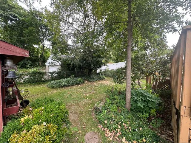 a view of backyard of house with green space