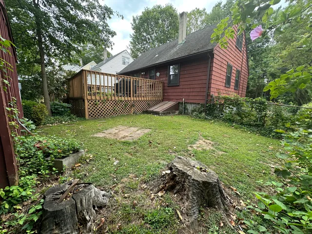 a view of a house with a small yard and wooden fence