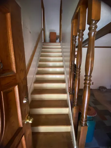 a view of staircase with white walls and railing