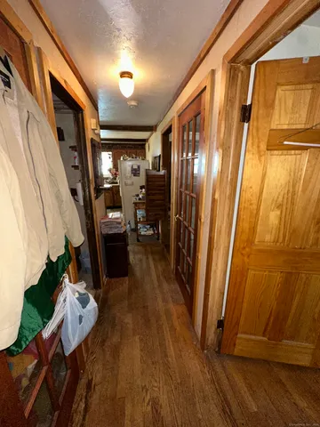 a view of a hallway with wooden floor and staircase