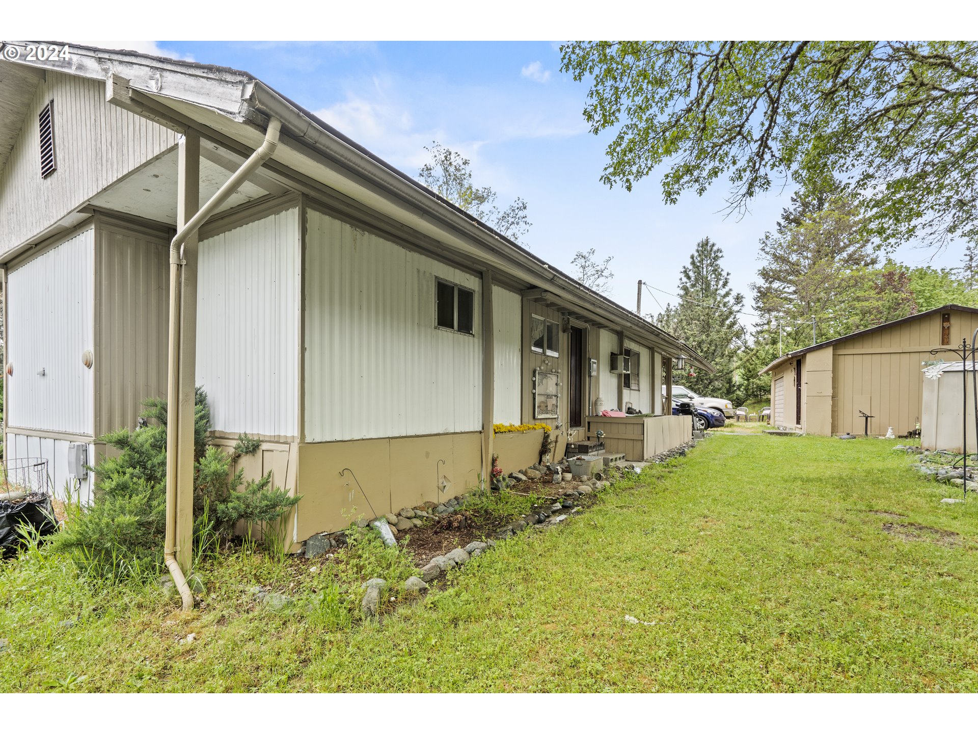 403 Azalea Drive Grants Pass, OR 97526 - Photo 13 of 17 a backyard of a house with plants and large tree