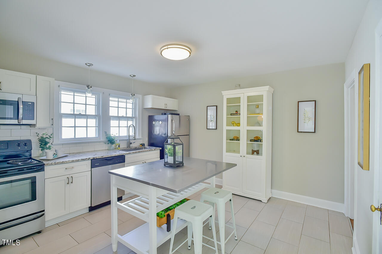 2411 Farthing Street Durham, NC 27704 - Photo 24 of 47 a kitchen with stainless steel appliances granite countertop a sink stove and refrigerator