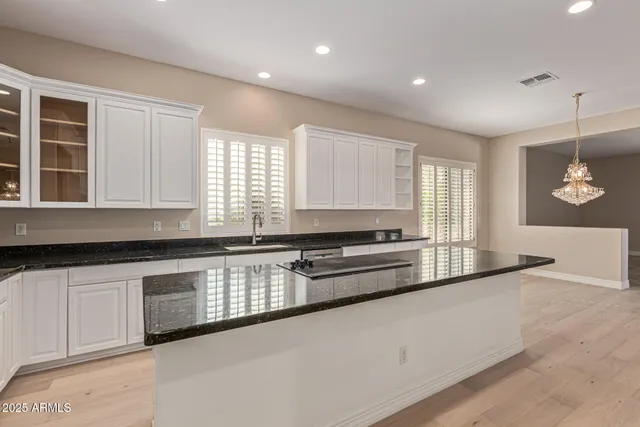 a kitchen with granite countertop a stove a sink and a refrigerator