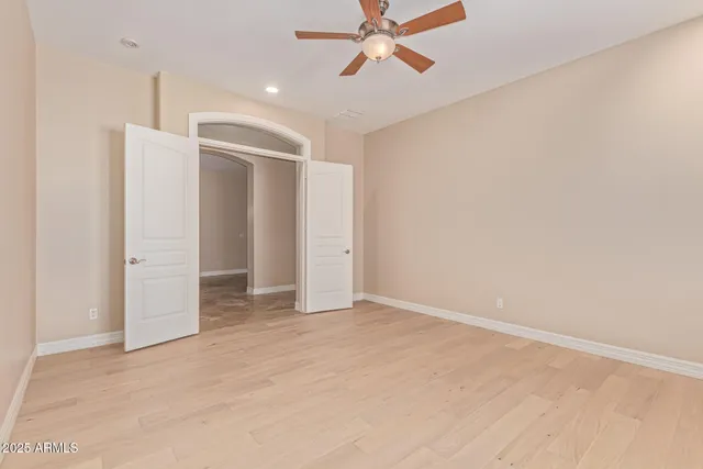 a view of a big room with windows and chandelier fan