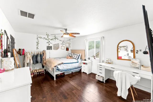 a view of a livingroom with wooden floor and white cabinets