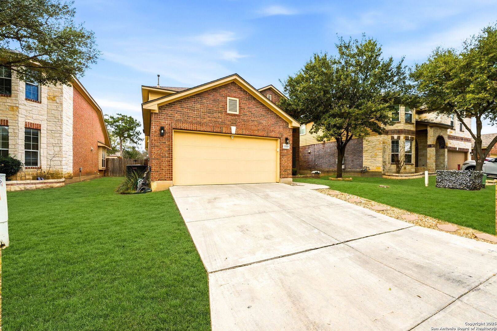 13119 Moselle Forest Helotes, TX 78023 - Photo 3 of 38 a front view of a house with a garden and trees