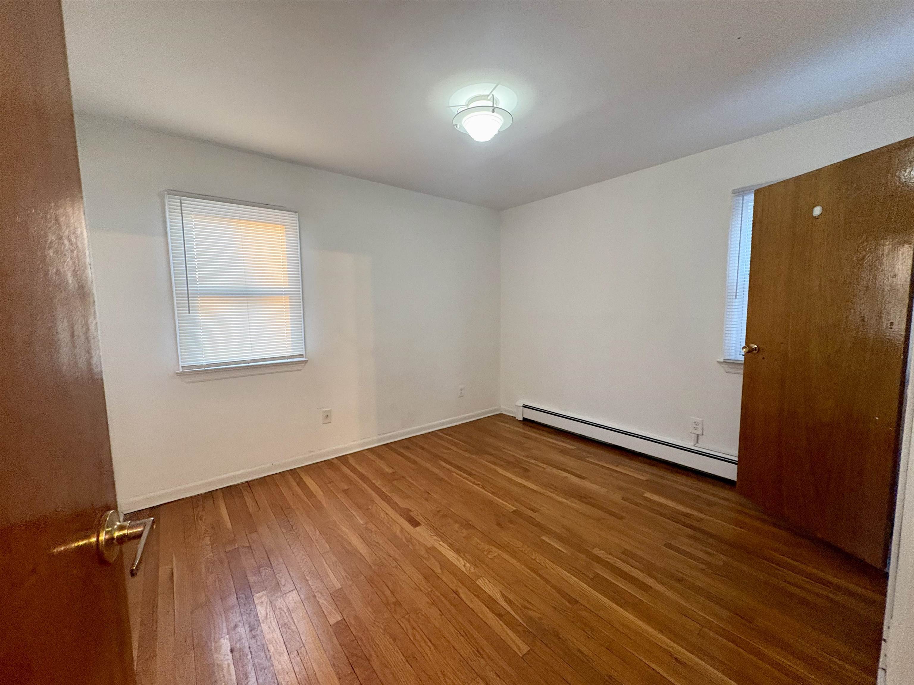 30 Kennedy Street, Unit 2 Hackensack, NJ 07601 - Photo 3 of 11 an empty room with wooden floor and windows