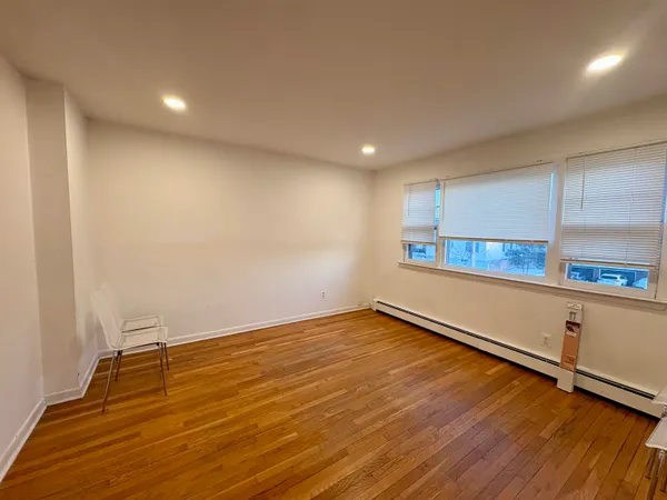 a view of a room with wooden floor and window