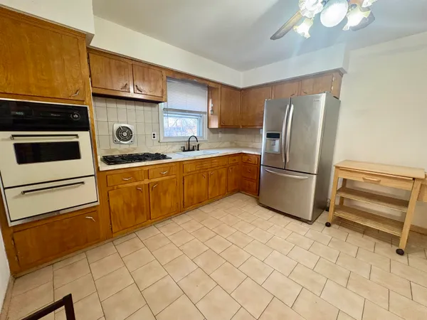 a kitchen with a refrigerator sink and cabinets
