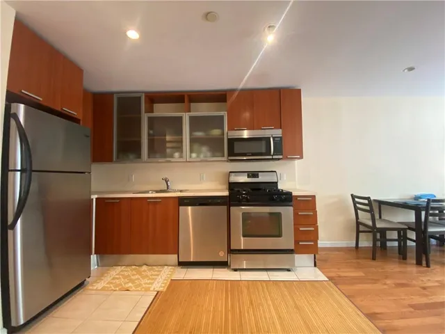a kitchen with stainless steel appliances granite countertop a refrigerator and a stove top oven