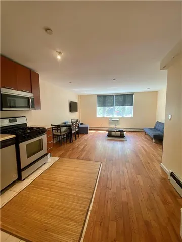 a view of a kitchen with furniture and wooden floor