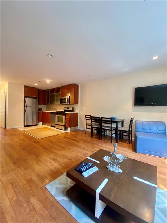 327 101st Street, Unit C Brooklyn, NY 11209 - Photo 4 of 8 a living room with furniture and a flat screen tv