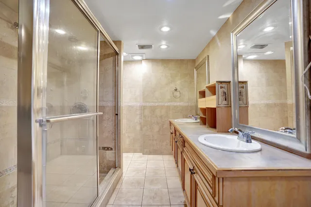 a bathroom with a sink shower and a mirror