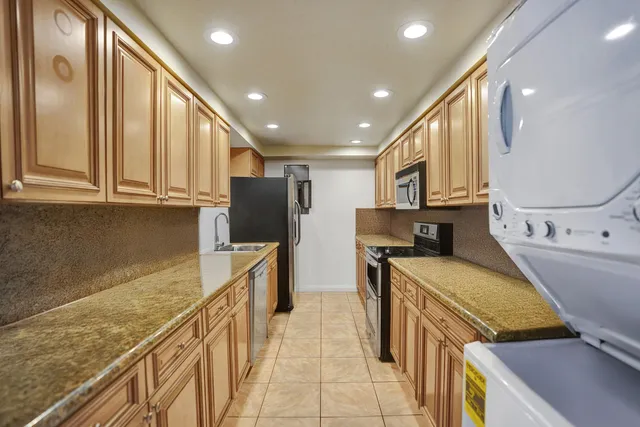 a kitchen with stainless steel appliances granite countertop a stove a sink and a refrigerator