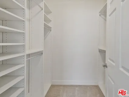 a view of walk in closet with empty racks