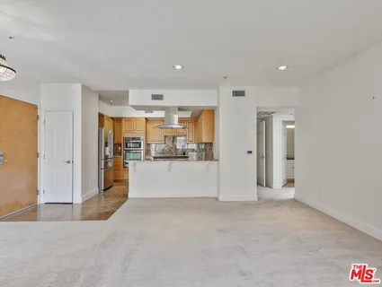 a view of a kitchen with refrigerator and white cabinets