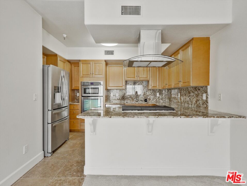 937 12th Street, Unit 308 Santa Monica, CA 90403 - Photo 10 of 39 a kitchen with stainless steel appliances granite countertop a sink and a refrigerator