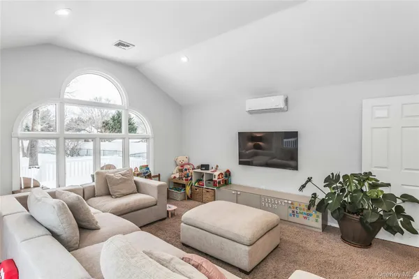 a living room with furniture a large window and a flat screen tv