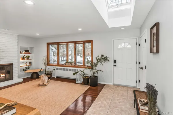 a living room with furniture a fireplace and a large window
