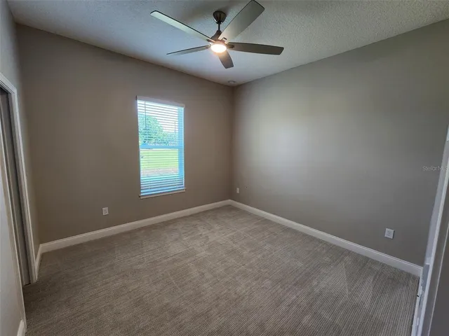 a view of empty room with ceiling fan