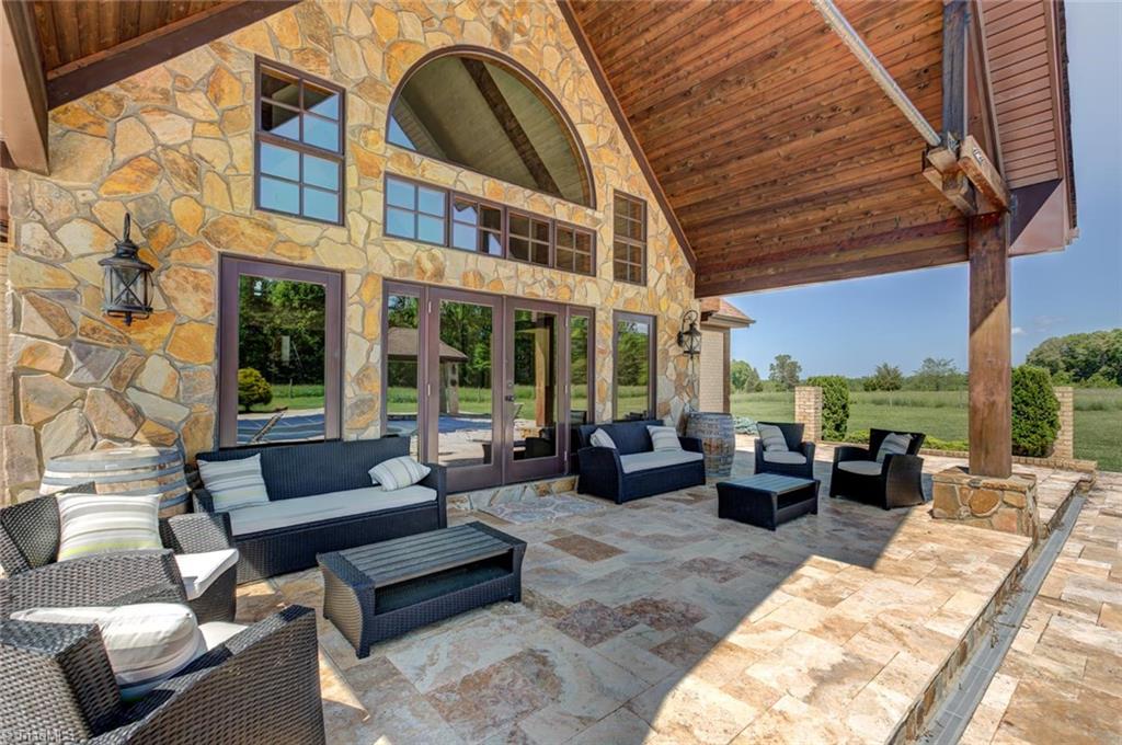 494 Ledbetter Road Mayodan, NC 27027 - Photo 7 of 30 Covered patio with travertine decking overlooking pool. Great for entertaining