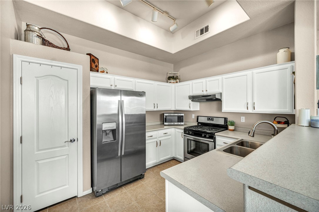 2305 West Horizon Ridge Parkway, Unit 3621 Henderson, NV 89052 - Photo 8 of 23 A well-equipped kitchen features white cabinetry and stainless steel appliances, offering ample storage and culinary space.