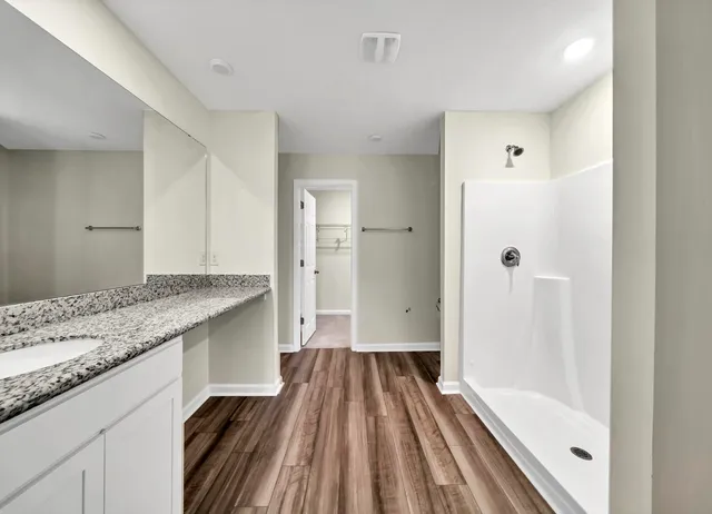 a bathroom with a granite countertop sink toilet and shower