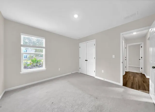 an empty room with windows and closet