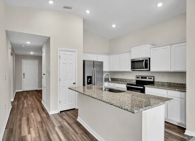 a kitchen with stainless steel appliances granite countertop a sink stove and refrigerator