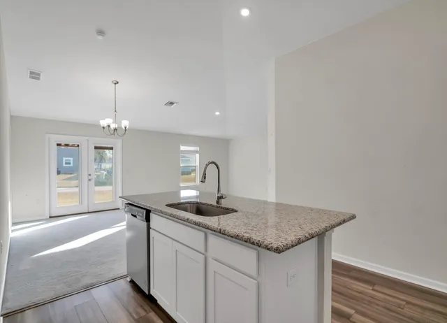 a bathroom with a granite countertop sink a mirror and a bathtub