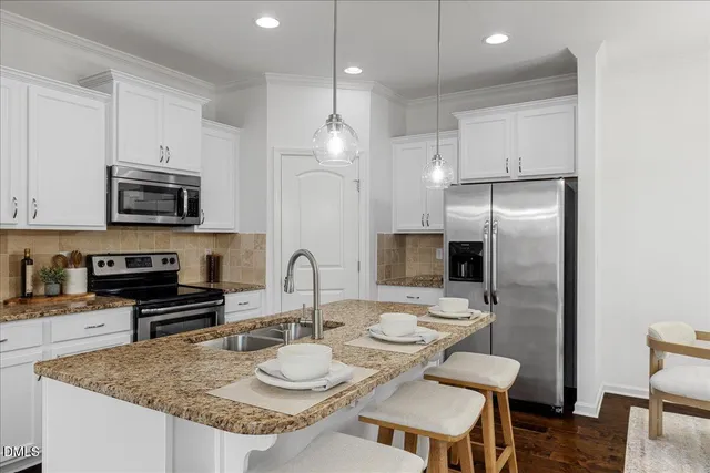 a kitchen with granite countertop a sink a center island and stainless steel appliances