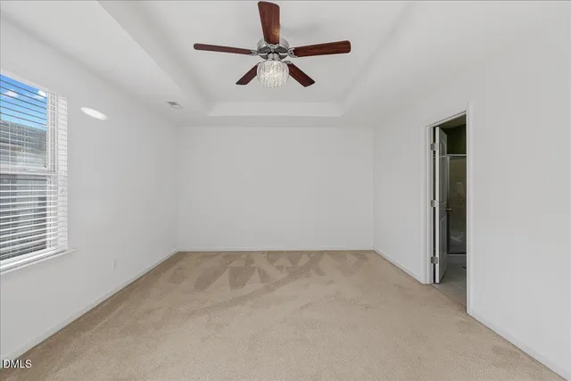 an empty room with a window and a ceiling fan