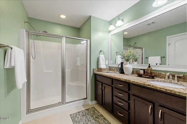 a bathroom with double vanity and a mirror