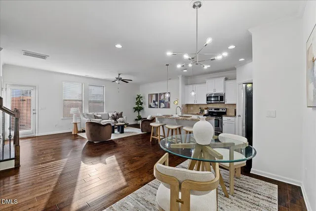 a living room with furniture a kitchen view and a chandelier