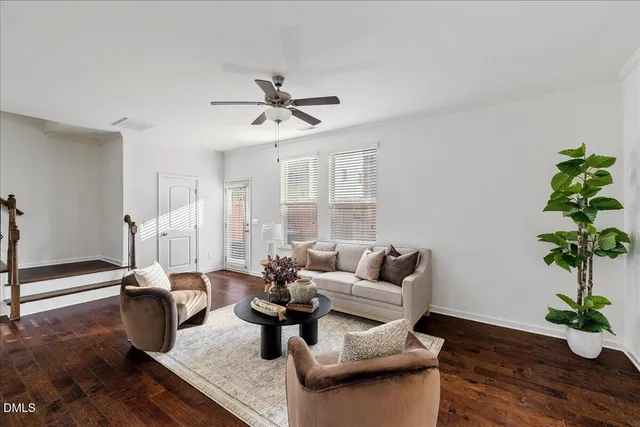 a living room with furniture potted plant and wooden floor