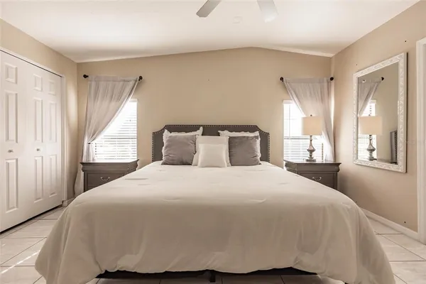 a bedroom with a large bed and wooden floor