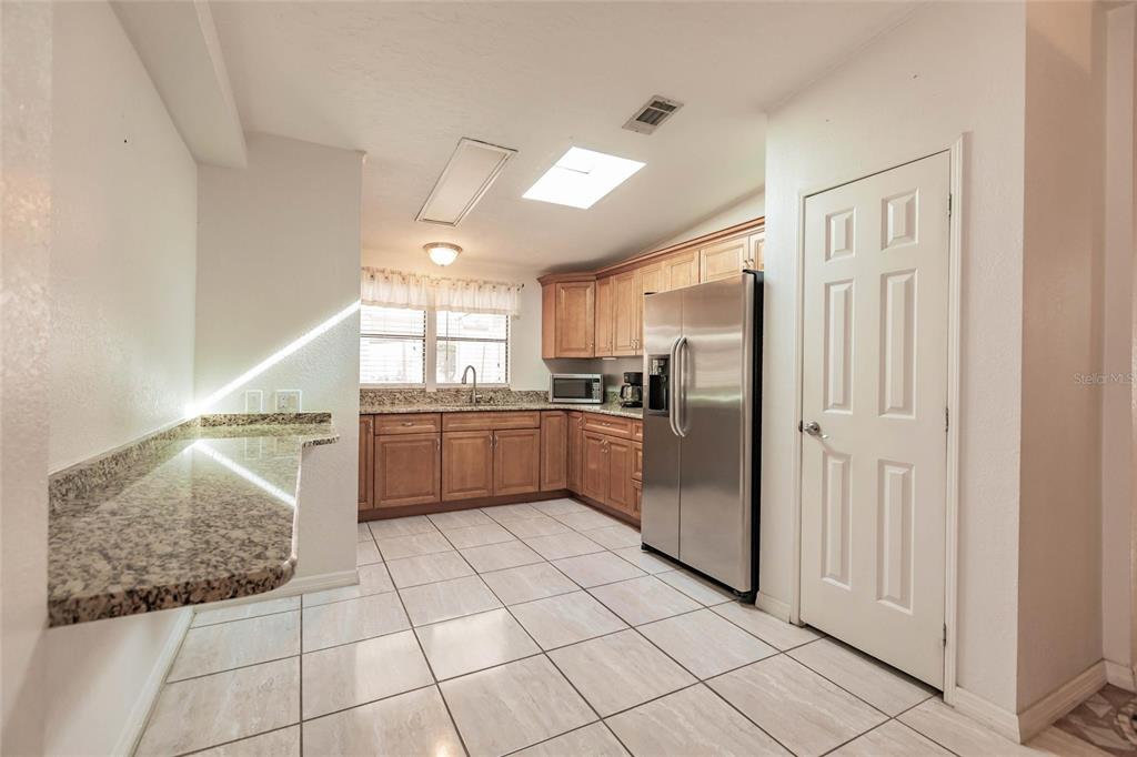 1961 Crystal Lane St. Cloud, FL 34769 - Photo 10 of 35 a kitchen with stainless steel appliances granite countertop a refrigerator and a sink