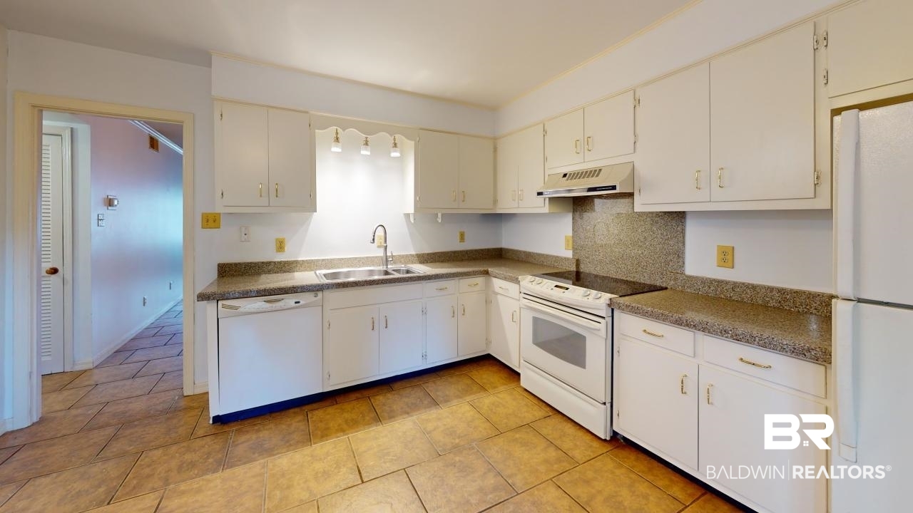 4009 Old Shell Road, Unit C13 Mobile, AL 36608 - Photo 11 of 32 Kitchen featuring white appliances, a sink, range hood, backsplash, and white cabinets