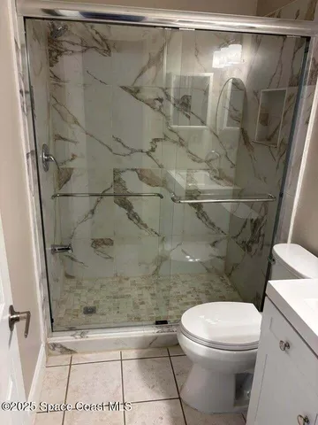 a bathroom with a toilet and a shower