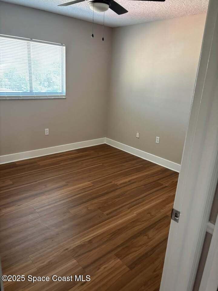 1720 Murrell Road, Unit 214 Rockledge, FL 32955 - Photo 7 of 8 wooden floor in an empty room with a window