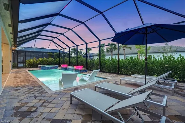 a view of a patio with a table and chairs under an umbrella