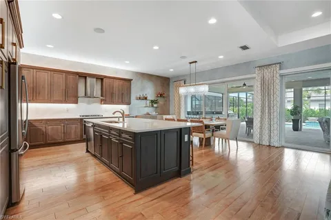 a kitchen with lots of wooden cabinets a sink a counter top space and stainless steel appliances
