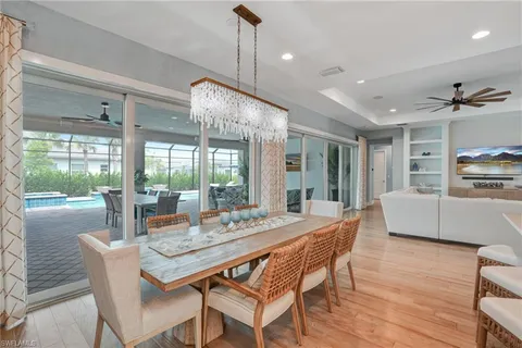 a dining room with furniture a chandelier and wooden floor