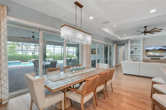 a dining room with furniture a chandelier and wooden floor