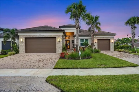 a front view of a house with a garden and palm tree