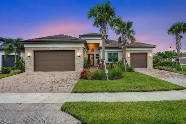 a front view of a house with a garden and palm tree